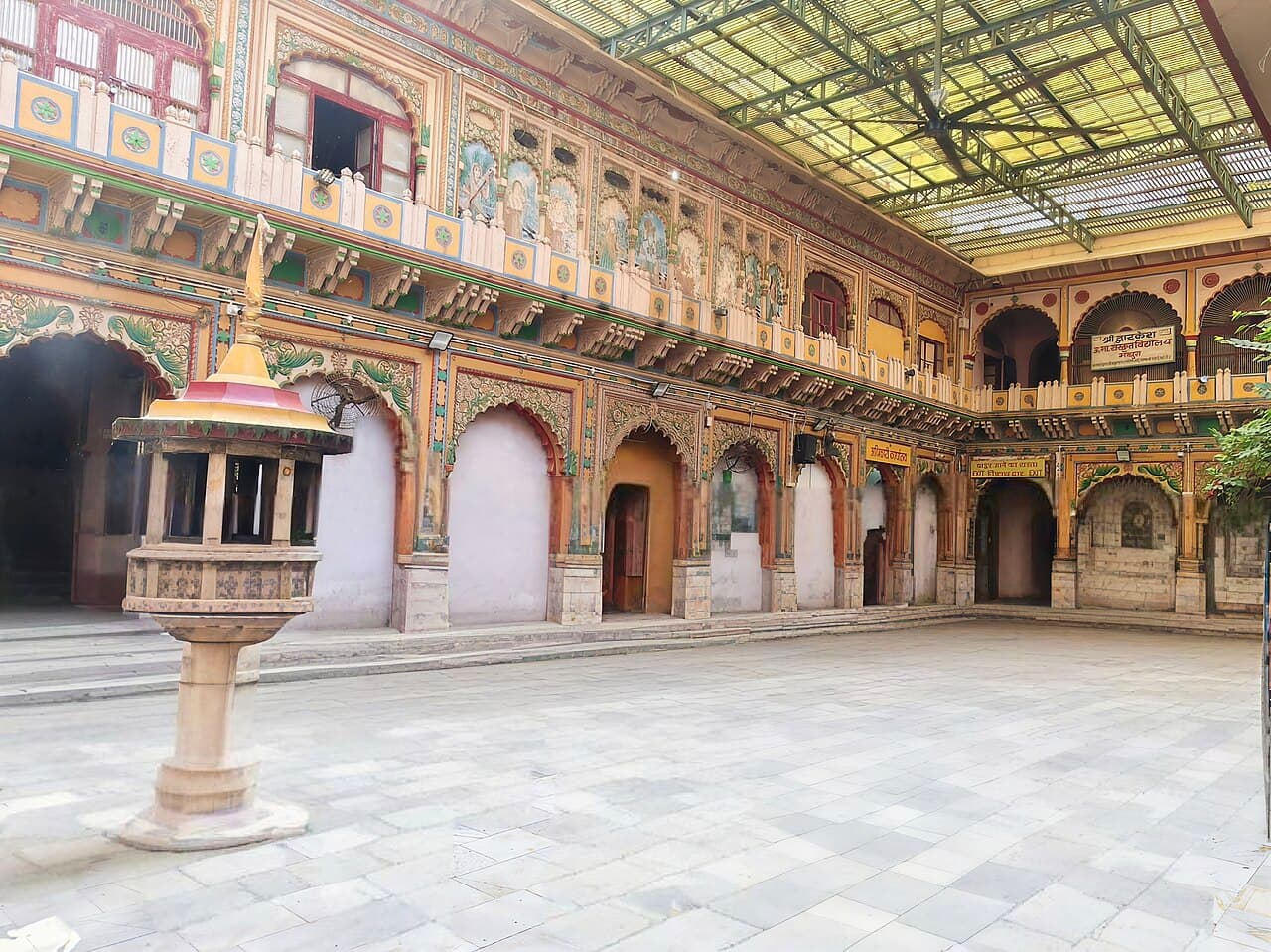 The painted Rajasthani courtyard of the Dwarkadhish haveli, Mathura, arcaded on two storeys beneath its galleries of Krishna's life